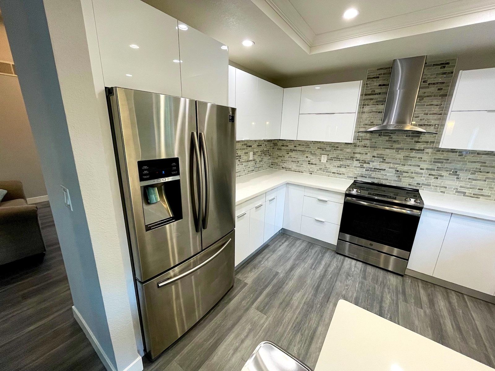 Rebuilt kitchen with white cabinets after refrigerator supply-line water damage